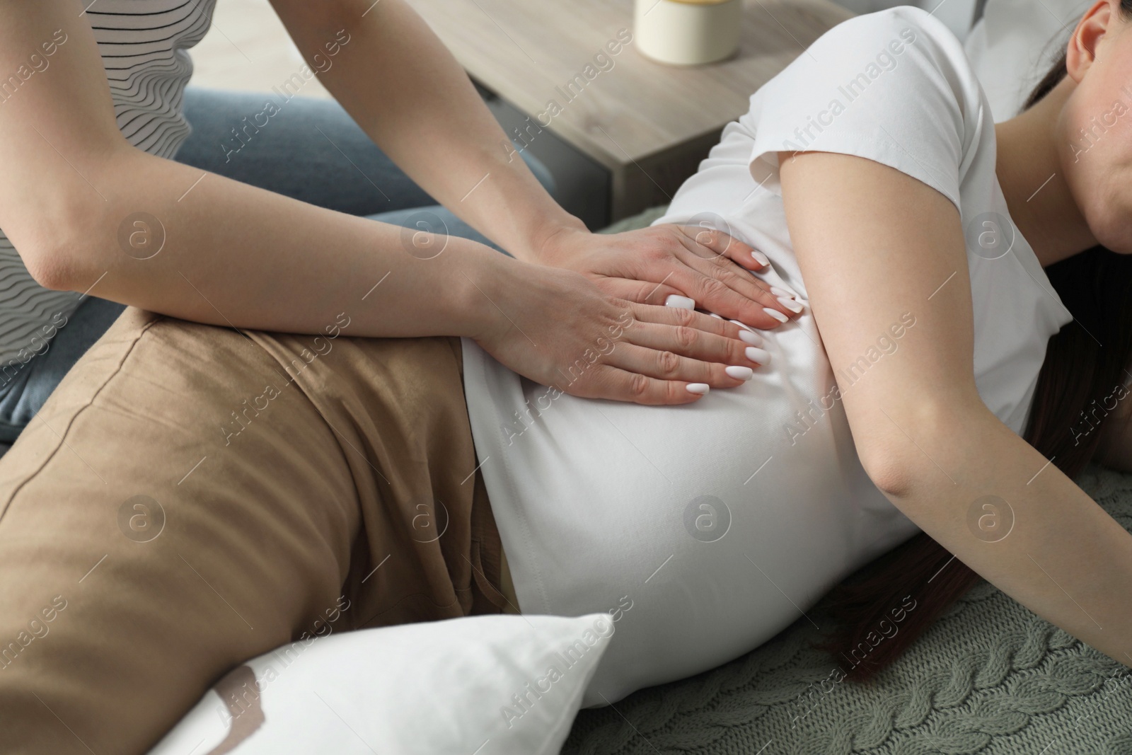 Photo of Doula taking care of pregnant woman indoors, closeup. Preparation for child birth