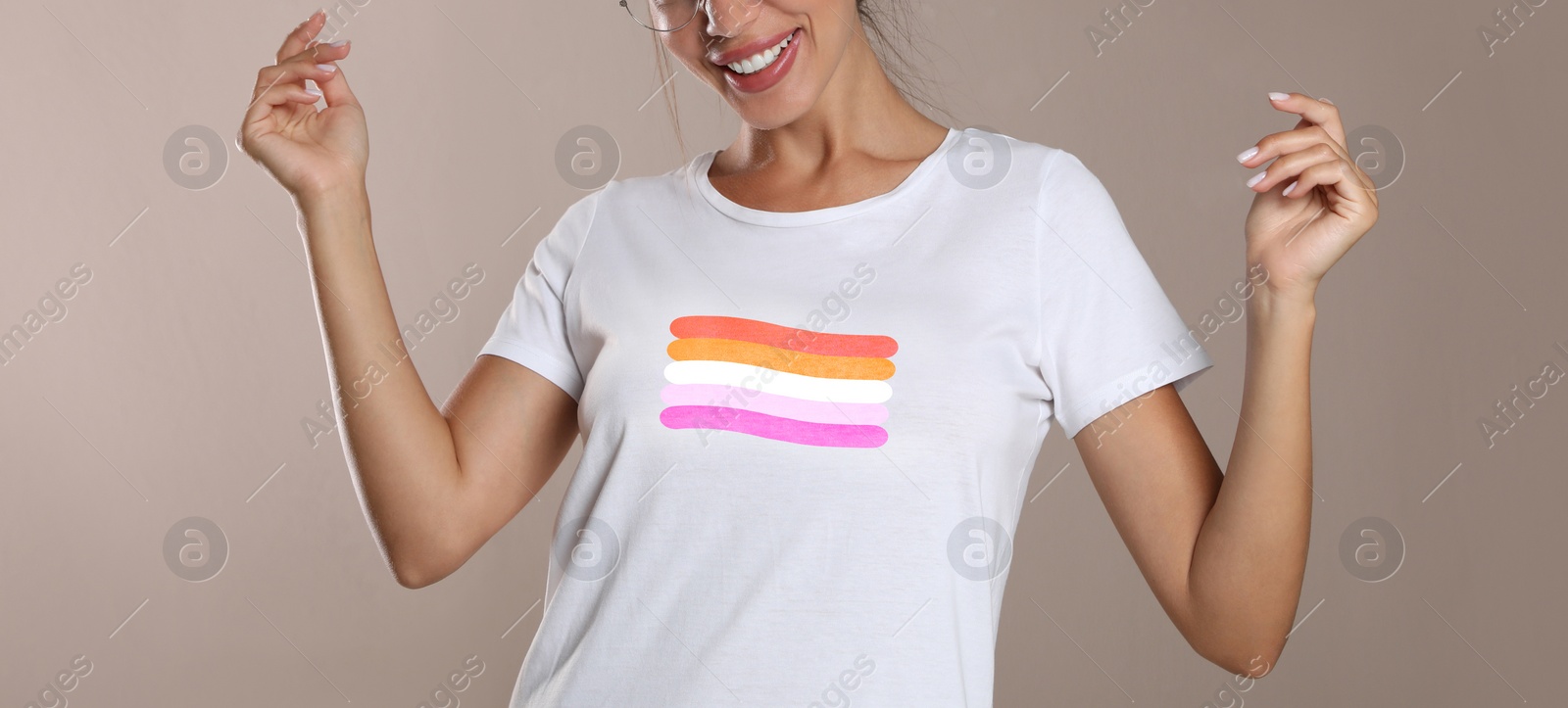 Image of Young woman wearing white t-shirt with lesbian flag on beige background, banner design. LGBT concept