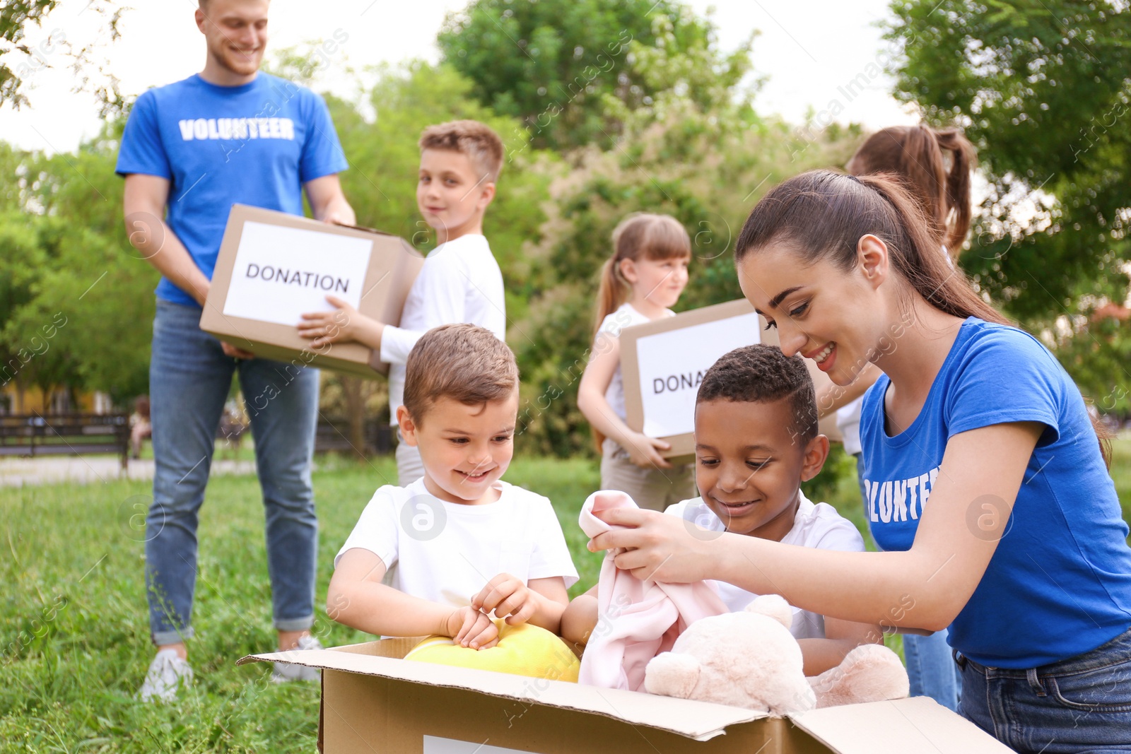 Photo of Volunteers and kids with donation boxes in park