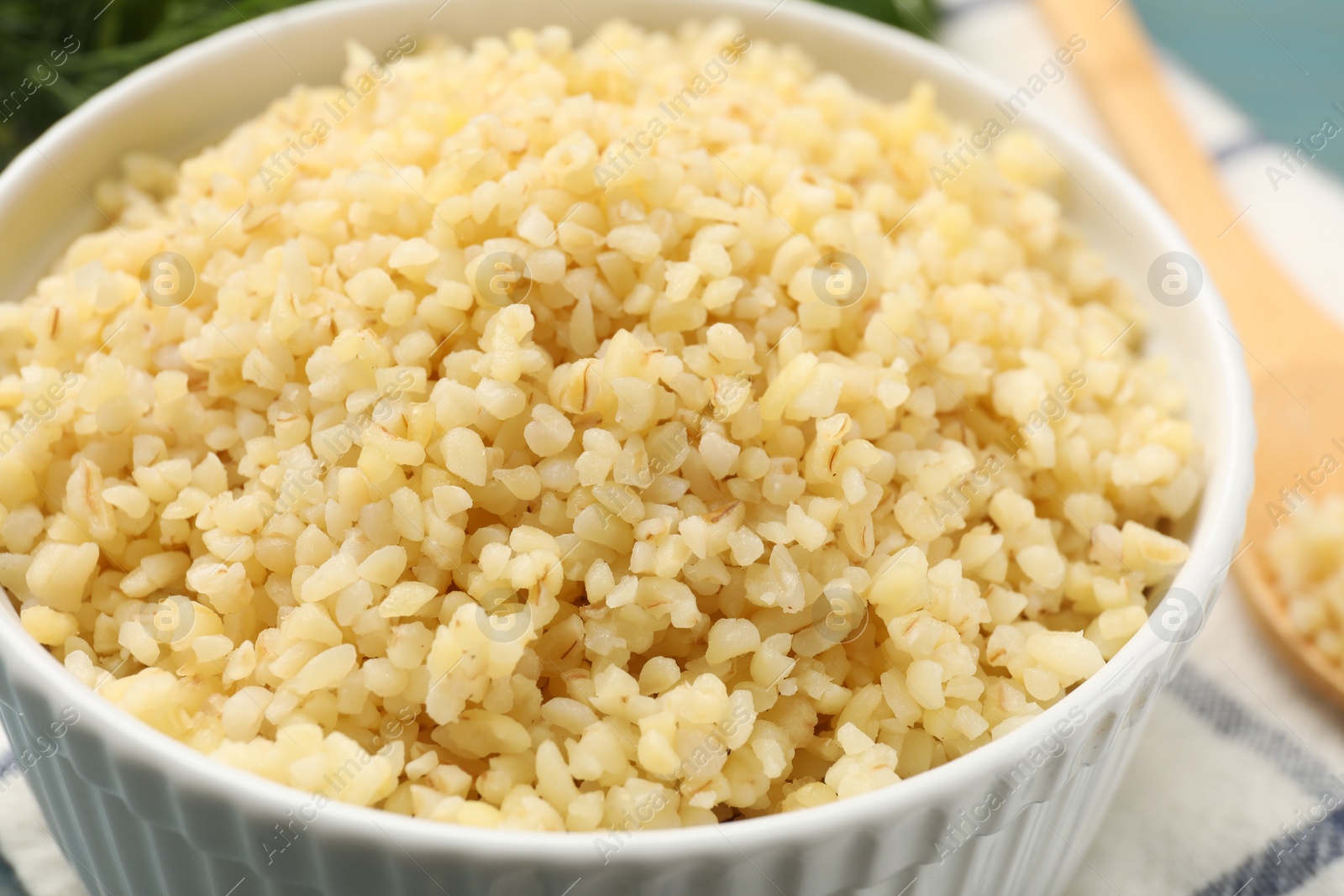 Photo of Delicious bulgur in bowl on table, closeup