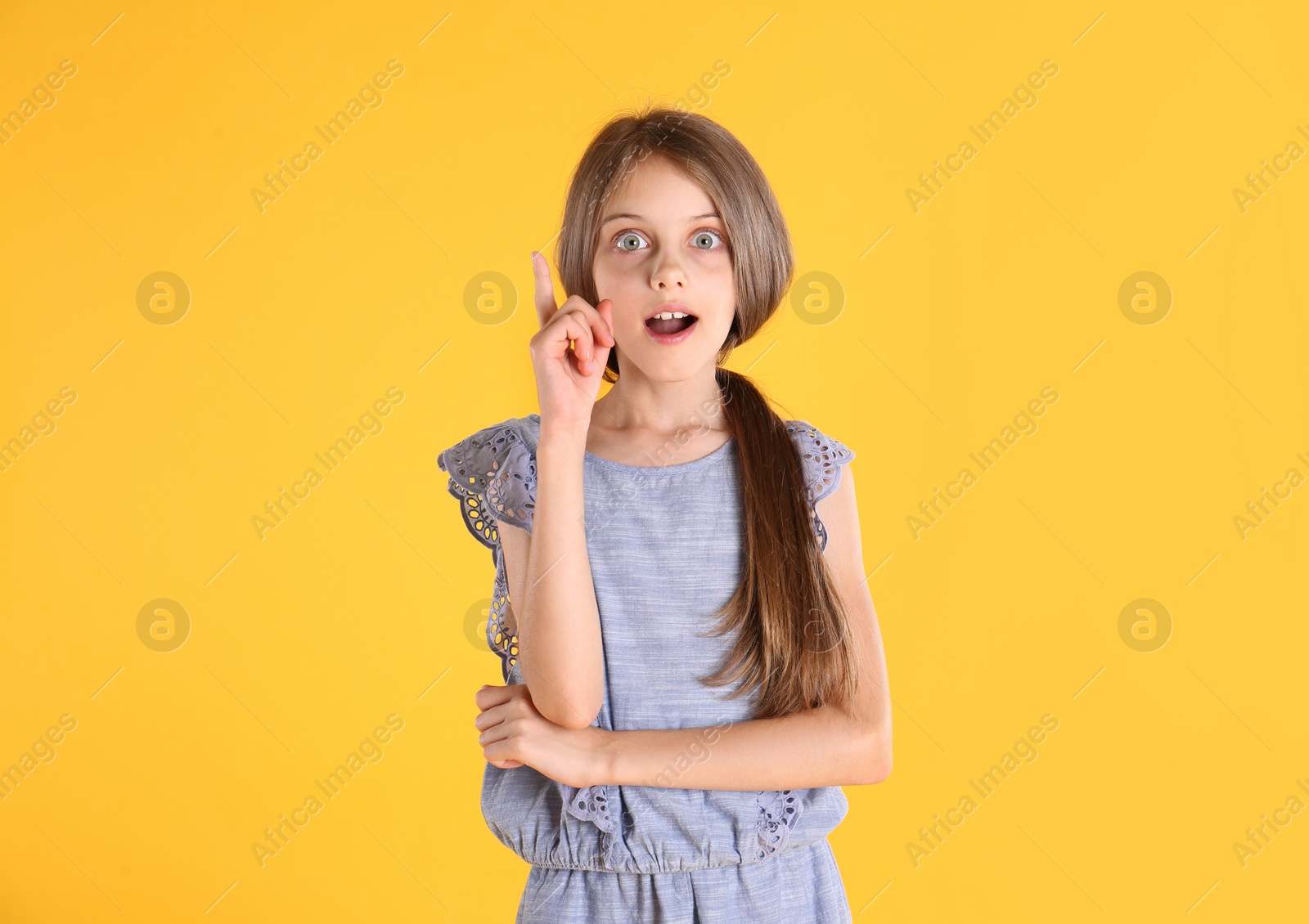 Photo of Portrait of emotional little girl on yellow background