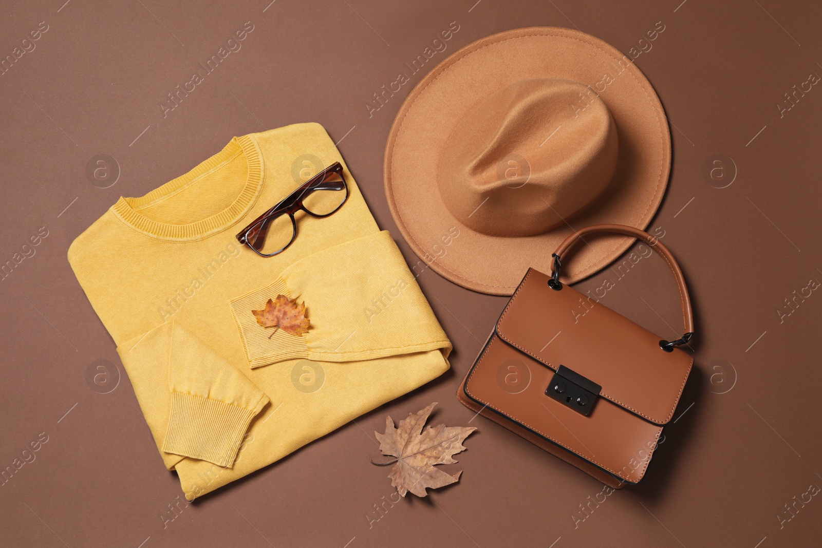 Photo of Flat lay composition with stylish hat on brown background