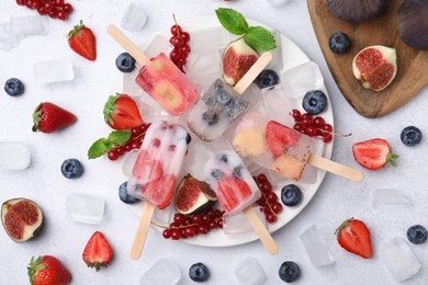 Photo of Flat lay composition with fruit and berry ice pops on white table