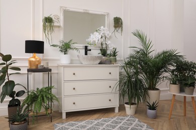Photo of Stylish bathroom interior with modern furniture and beautiful houseplants