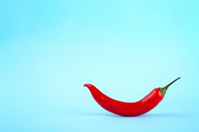 Photo of Ripe hot chili pepper on color background