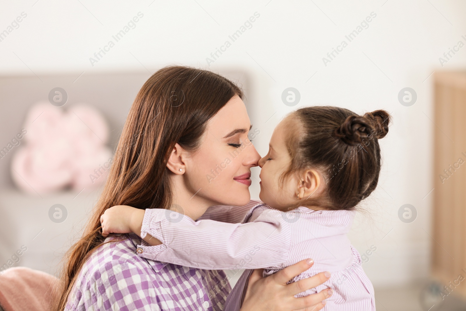 Photo of Young mother with little daughter at home