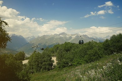 View of cableway with modern cabins in mountains