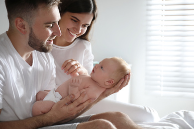 Happy couple with their newborn baby at home