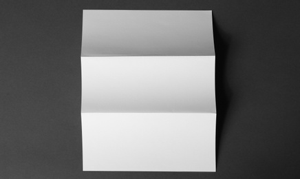 Photo of Blank brochure on dark grey background, top view. Mock up for design