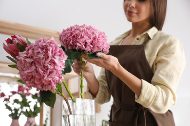 Florist with beautiful flowers in workshop, closeup