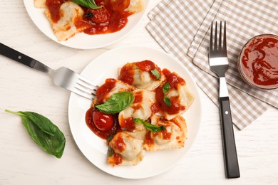 Photo of Tasty ravioli with tomato sauce served on white wooden table, flat lay