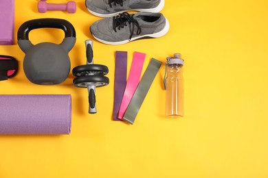 Photo of Different sports equipment on yellow background, flat lay. Space for text
