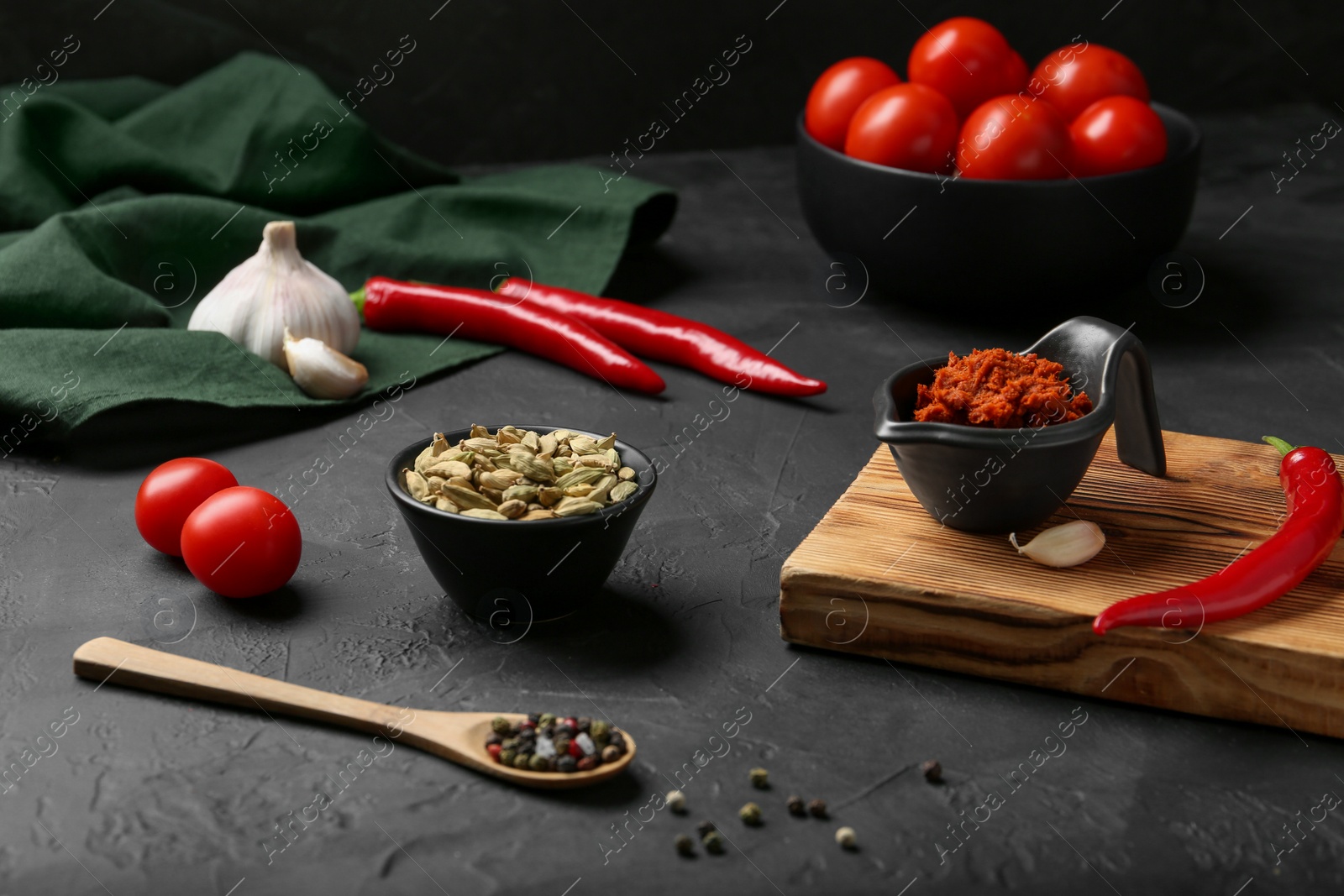 Photo of Dish with red curry paste and ingredients on black table