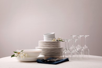 Photo of Set of clean dishware, cutlery and wine glasses on table indoors