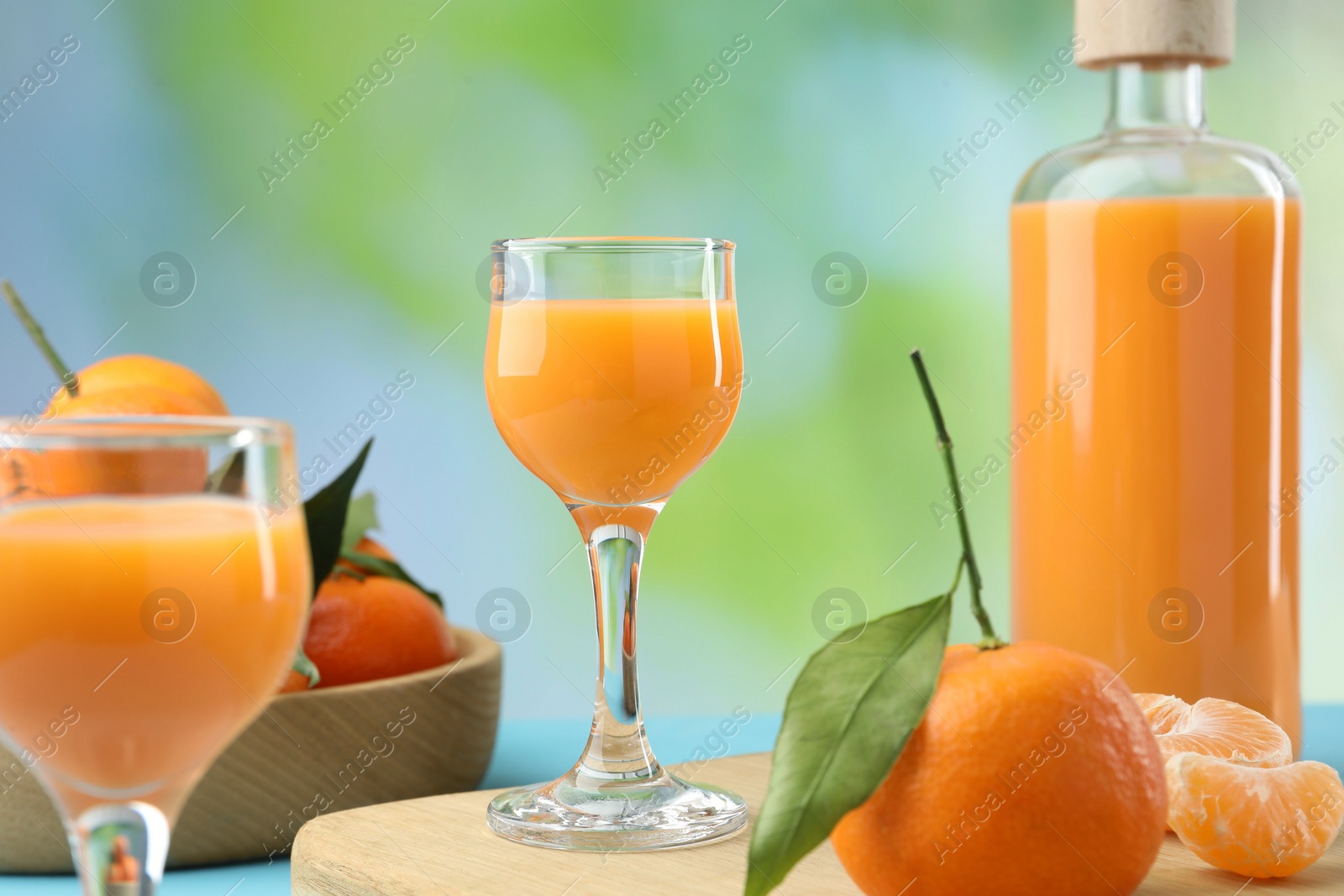 Photo of Delicious tangerine liqueur and fresh fruits on table