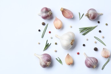 Fresh garlic, rosemary and peppercorns on white background, flat lay. Space for text