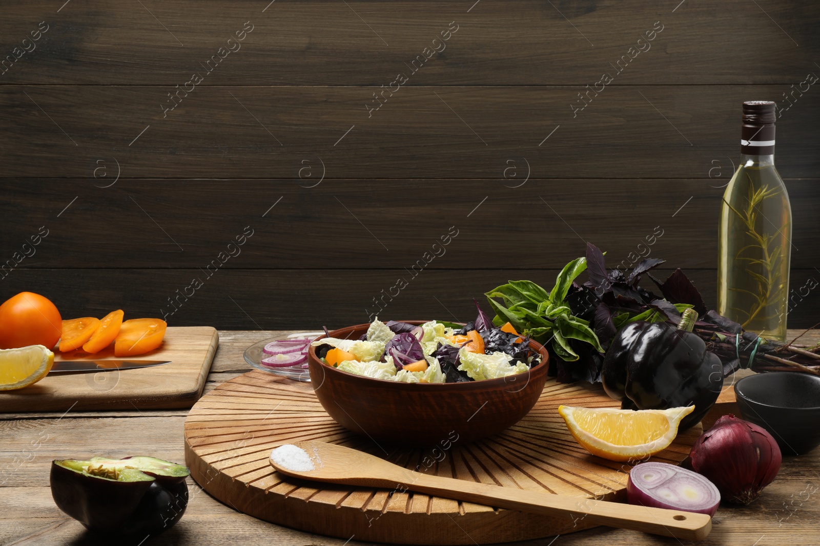 Photo of Delicious salad with Chinese cabbage, tomato and basil served on wooden table