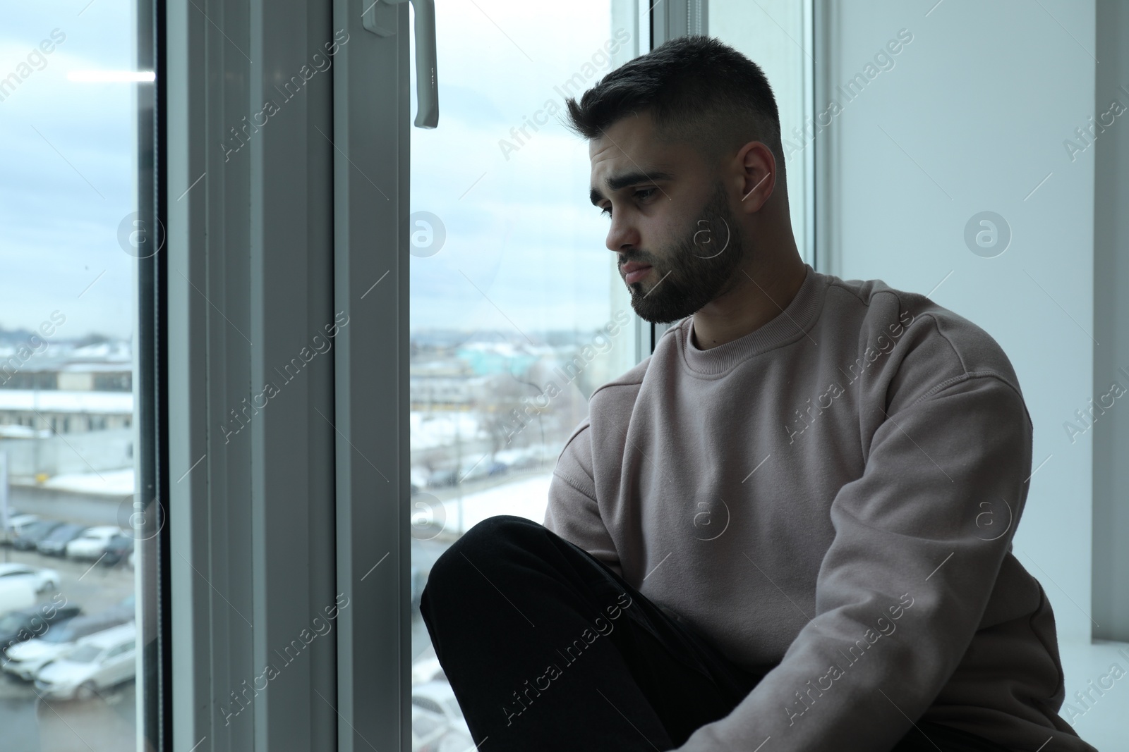 Photo of Sad man looking at window at home