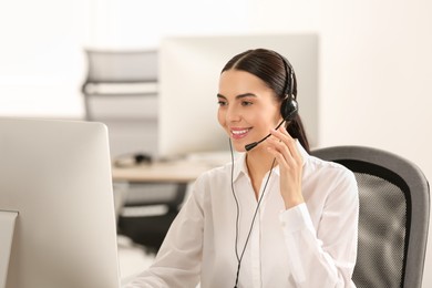 Photo of Hotline operator with headset working on computer in office