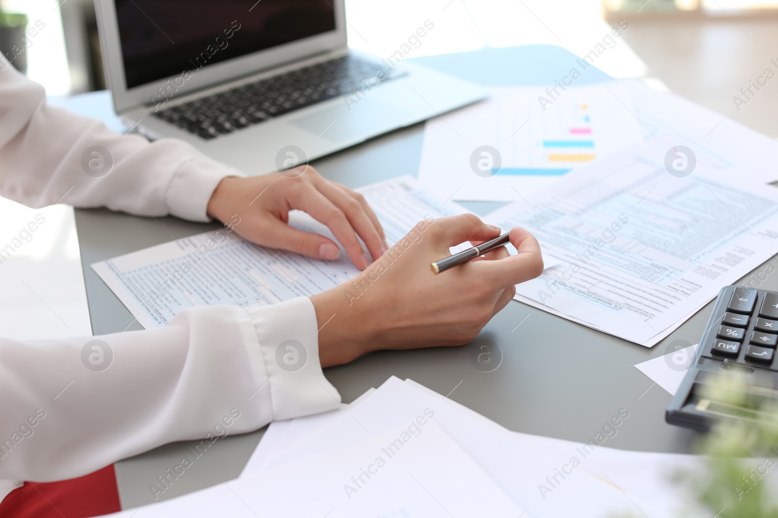 Photo of Tax accountant working with documents at table