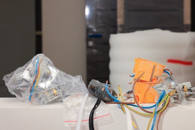 Photo of Mounting boxes, wires and measuring tape indoors
