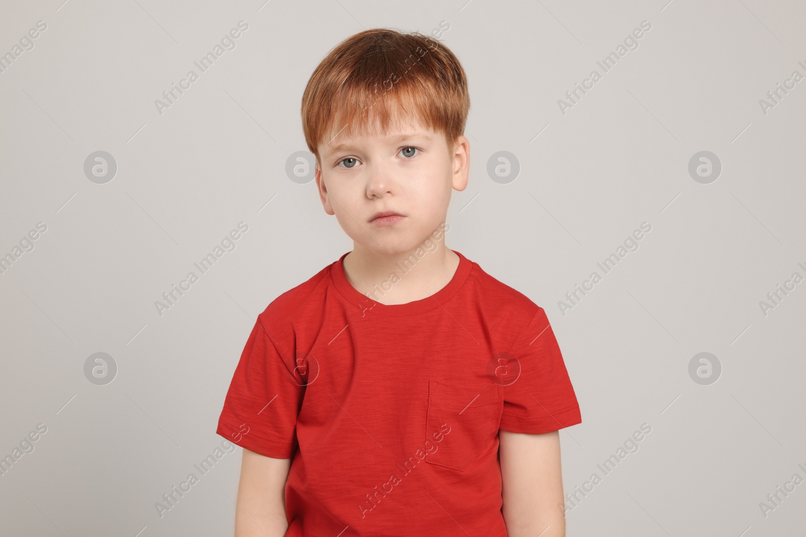 Photo of Upset boy on light grey background. Children's bullying