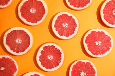 Photo of Fresh sliced ripe grapefruit on color background, flat lay