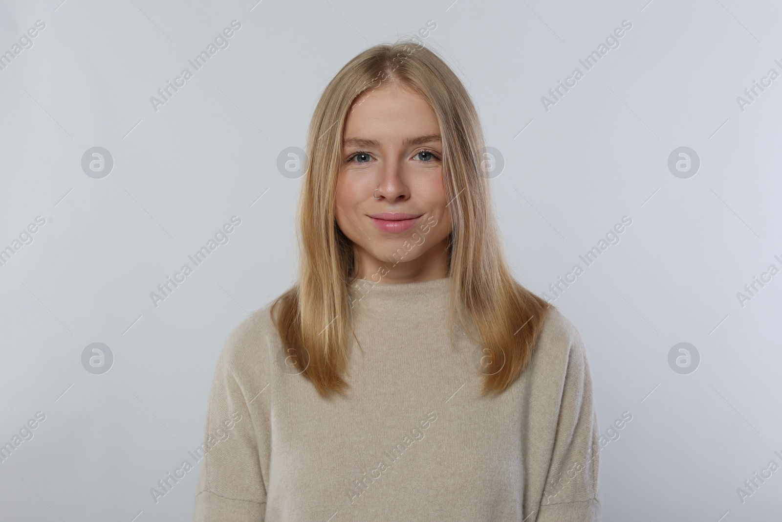 Photo of Portrait of beautiful young woman in stylish sweater on white background