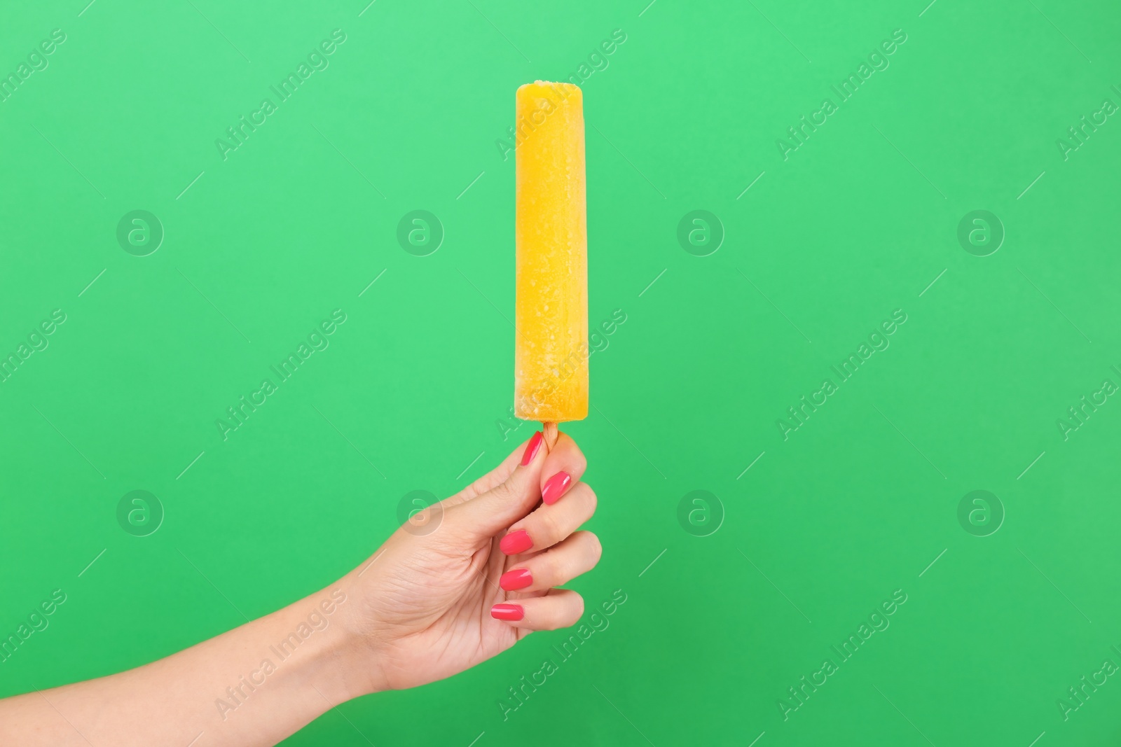 Photo of Woman holding yummy ice cream on color background. Focus on hand