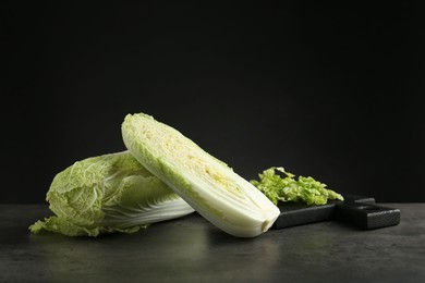 Whole and cut fresh Chinese cabbages on grey table