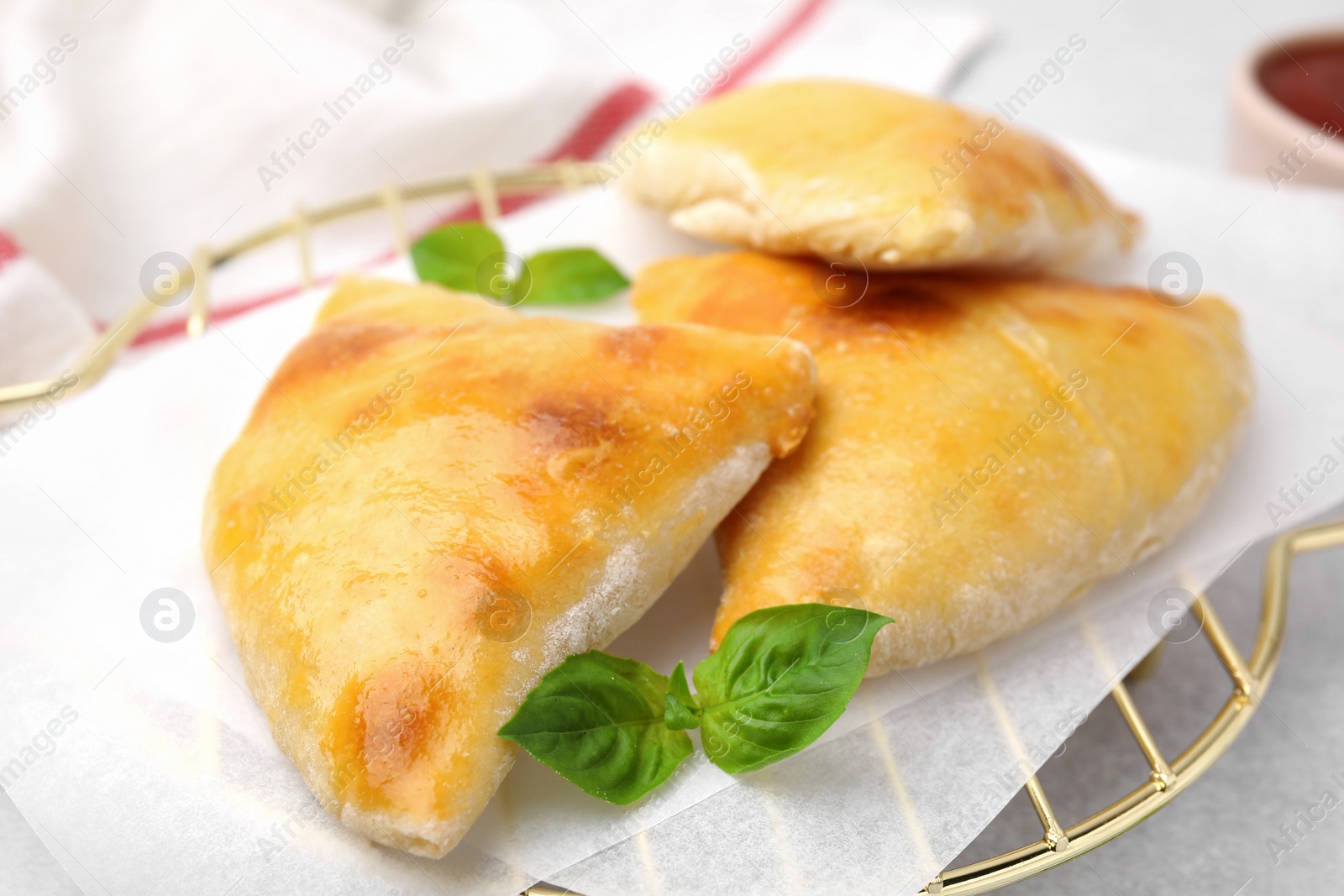 Photo of Delicious samosas and basil on white table, closeup