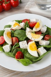 Photo of Delicious salad with boiled eggs, feta cheese and tomatoes on table, closeup