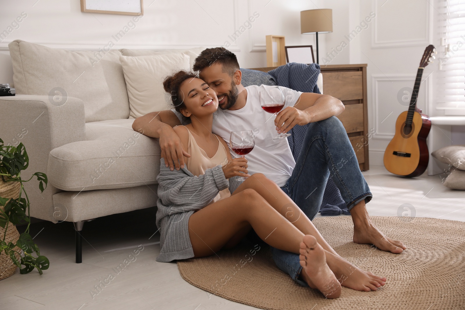 Photo of Lovely couple with glasses of wine enjoying time together at home