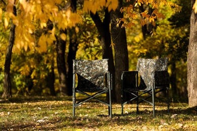 Pair of camping chairs in park on sunny day