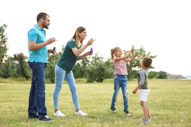 Photo of Happy family playing together with their children outdoors