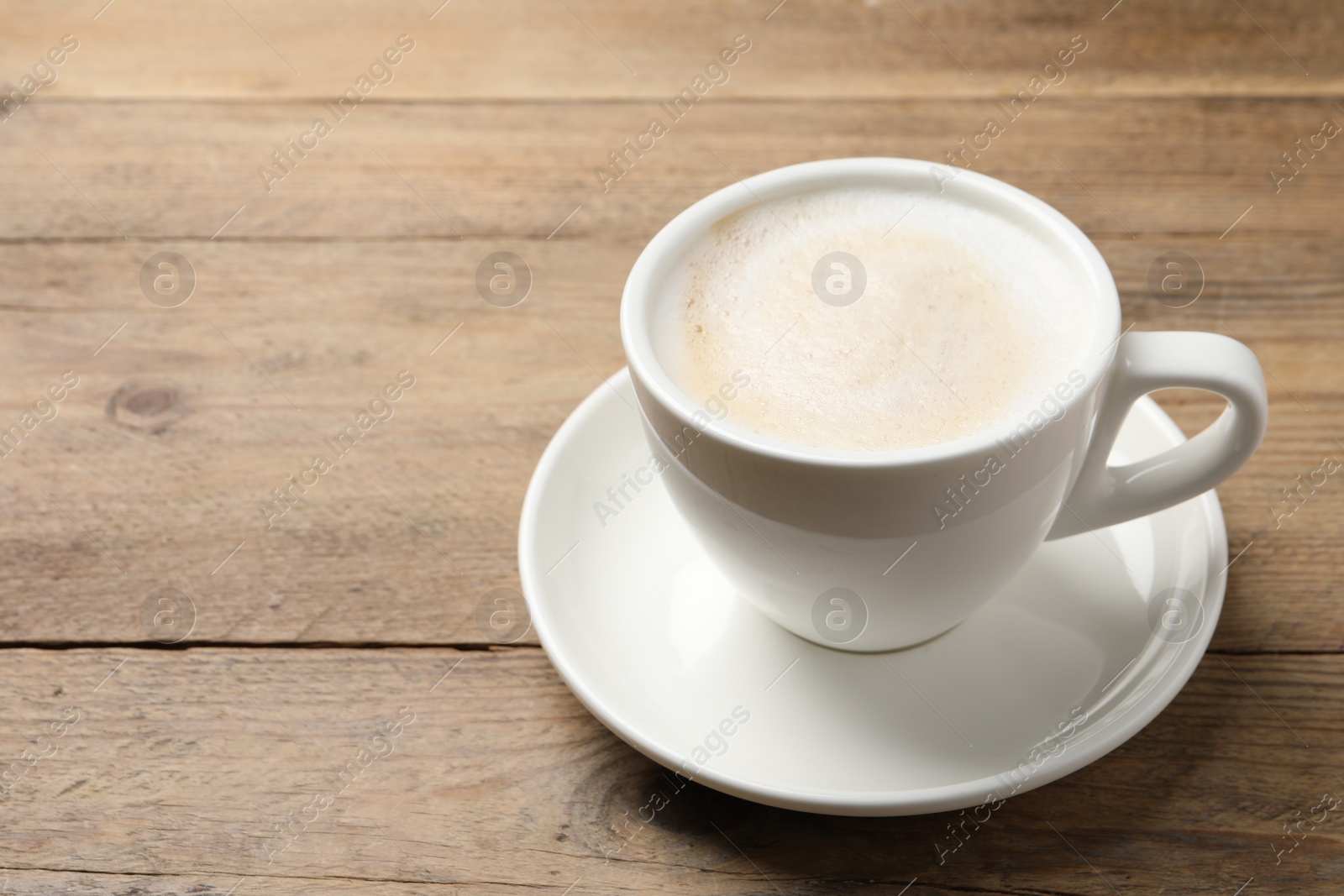 Photo of Cup of aromatic coffee on wooden table. Space for text