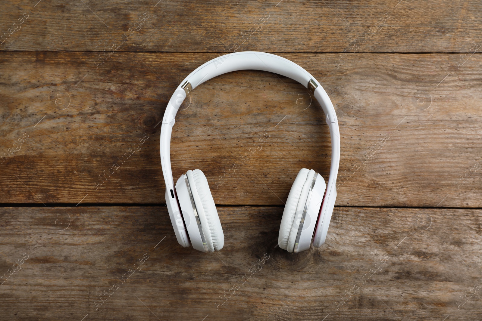 Photo of Stylish modern headphones on wooden background, top view