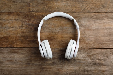 Stylish modern headphones on wooden background, top view