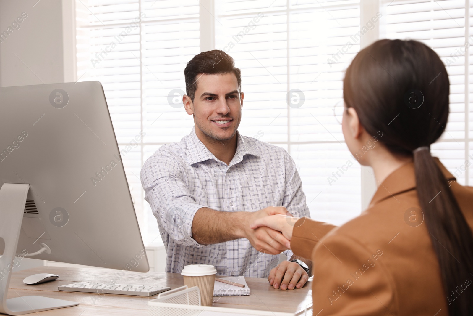 Photo of Employee shaking hands with intern in office