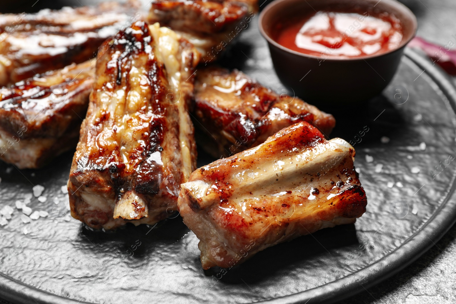 Photo of Delicious grilled ribs on board, closeup view