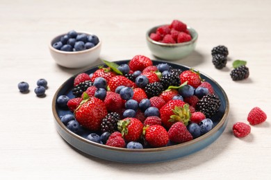 Different fresh ripe berries on light wooden table