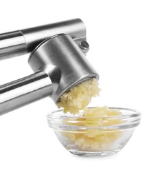 Photo of Squeezing garlic with press into bowl on white background