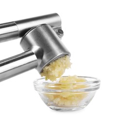 Squeezing garlic with press into bowl on white background