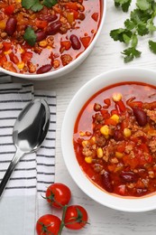 Photo of Tasty chili con carne served on white wooden table, flat lay