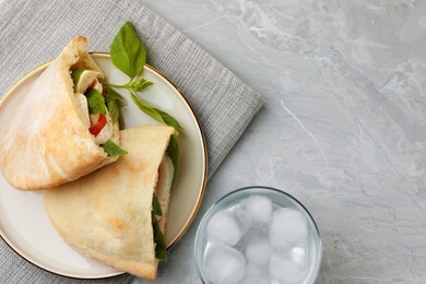 Photo of Delicious pita sandwiches with mozzarella, tomatoes and basil on light grey marble table, flat lay. Space for text