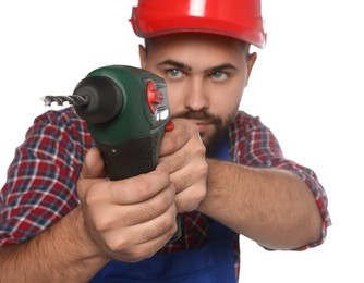 Photo of Young worker in uniform with power drill against white background, focus on tool