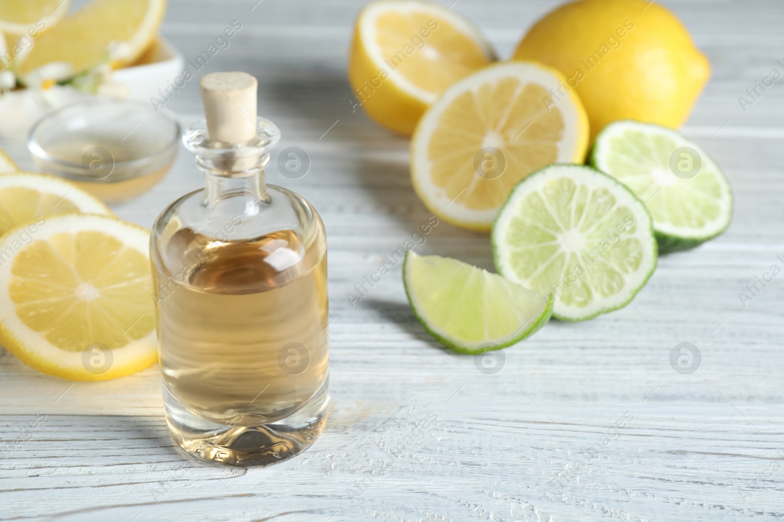 Photo of Citrus essential oil on white wooden table