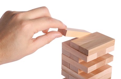 Playing Jenga. Man building tower with wooden blocks on white background, closeup