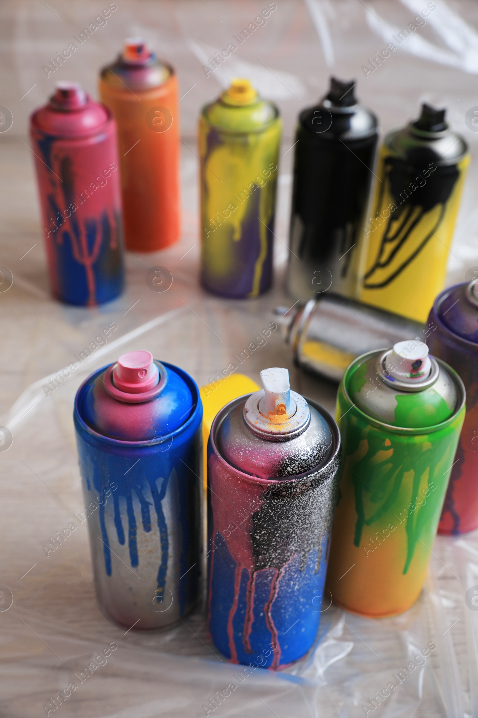 Photo of Used cans of spray paints on floor. Graffiti supplies