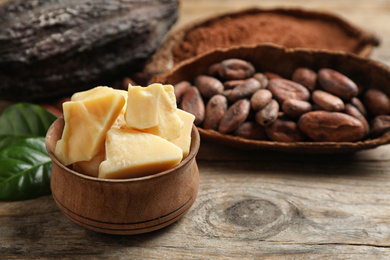 Photo of Organic cocoa butter on wooden table, closeup. Space for text